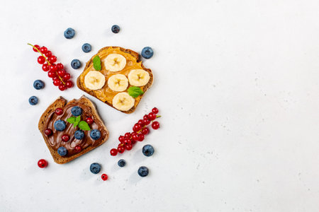 Variety of sweet sandwiches with peanut butter, chocolate butter, berry could, cream cheese,...