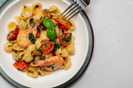 Italian pasta Orecchiette with sea food, prawns and cherry tomatoes. Close up.