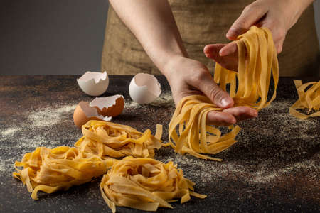 Close up of woman hands making italian pasta - tagliatelle.の写真素材