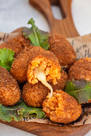 Rice balls stuffed with mozzarella cheese and deep fried. Close up. Copy space.の写真素材