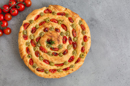 Homemade italian flat bread - Focaccia contorta. With olives, olive oil, rosemary, tomatoes....