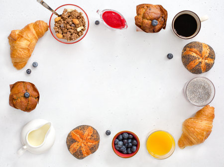 Modern continental breakfast, top view. Coffee, orange juice, milk, poppy seed buns, blueberry...