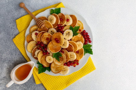 Homemade pancakes with red currant, honey and banana. Top view.