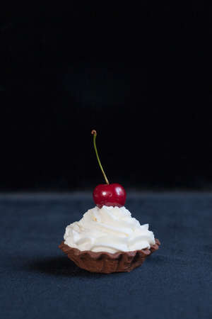 Homemade tartlet with cream cheese and cherry on dark background.の写真素材