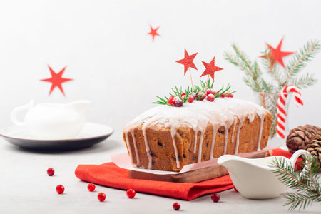 Christmas table:  fruit cake with cranberries, raisins and almonds, decorated with fresh cranberries...