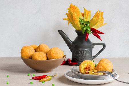 Arancini - italian rice balls which are coated with bread crumbs and then deep fried, filled with...