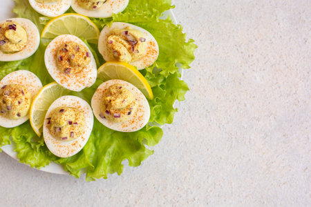 Deviled eggs with  maionese, mustard, chopped red onion, lemon and paprika on green salad....