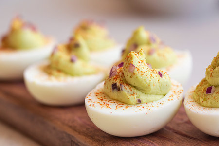 Deviled eggs with avocado, maionese, mustard, chopped red onion and paprika. Appetizer. Close-up.の写真素材