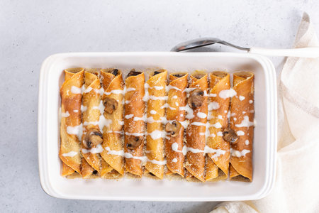 Baked crepes with mushrooms porcini and champignon, hard cheese and bechamel sauce.