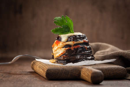 Parmigiana di melanzane - italian dish, deep fried sliced eggplants baked with mozzarella, parmezan cheese and tomato sauce. Decorated with parsley.の写真素材