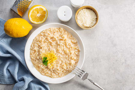Risotto with lemon zest and juice and parmesan in light grey background. Top view. Copy space.の写真素材