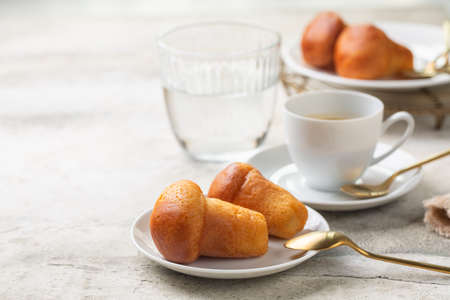 Italian breakfast. Rum baba and coffee espresso, glass of water. Selective focus. Light background.の写真素材