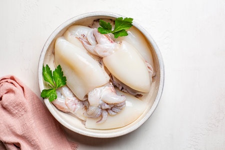 Cuttlefish sepia marine molluscs in a white plate, ready to be cooked.