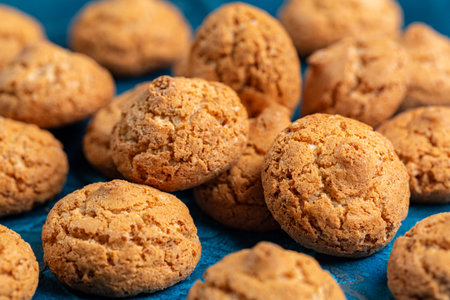 Amaretti cookies. Italian almond pastry, biscuits on a blue table surface.