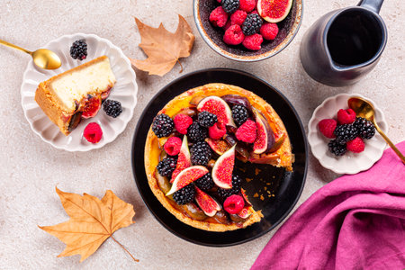 Homemade cheesecake with autumn fruits: figs, strawberries and blackberries. Breakfast table with dried leaves. Thanks giving day.の写真素材