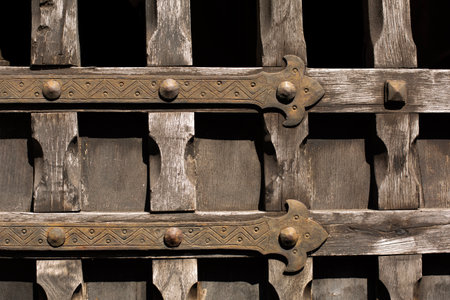 Medieval wooden door with decorated finges, vintage background.の写真素材