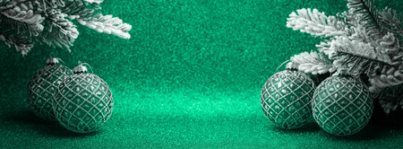 Green Christmas background with baubles decoration, xmas tree, sparkles with copy space. New Year or Merry Christmas greeting card. Winter holiday theme.の写真素材