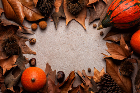 Beautiful autumn composition. Fall dried brown leafs, pumpkins, nuts, pine cones, chestnuts frame. Natural colours. Beige background. Copy space.の写真素材