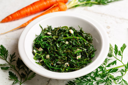 Sauteed carrot tops or greens with garlic and red pepper. Zero waste food concept.の写真素材