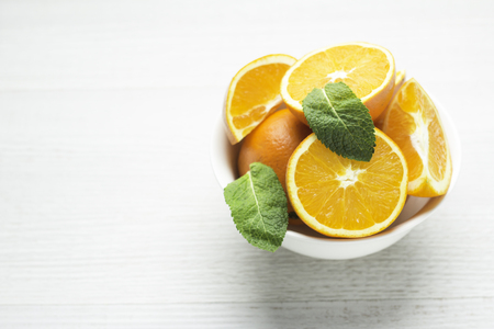 oranges in a white cup on a white backgroundの写真素材