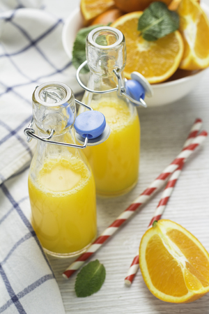 orange juice in bottles and orangesの写真素材
