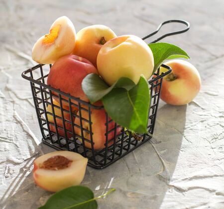 fresh sweet peach apricot in box on the table summer fruit light windowの写真素材