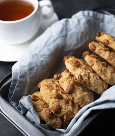 cookies with nuts and cup of tea on baking dish gray background close up top viewの写真素材