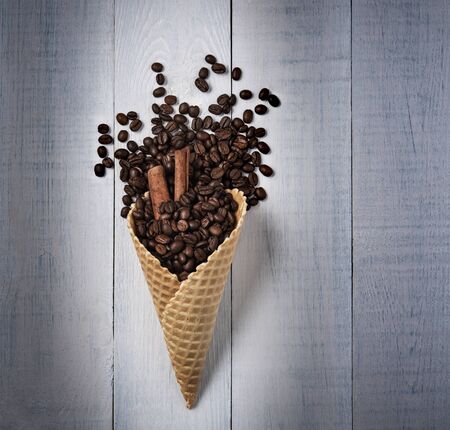 waffle cone with coffee beans and cinnamon scattered top view conceptの写真素材