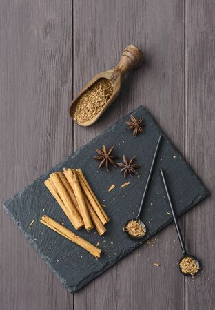 cinnamon stisk and powder on the wood brown table anise stars rustic close up spicyの写真素材