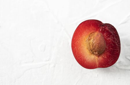 half sweet delicious plum on white table empty pure background macroの写真素材