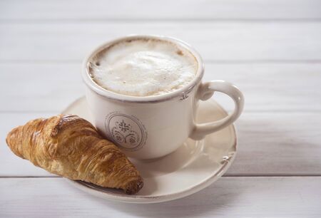 fresh coffee cappuchino and croissant wood background french morning breakfastの写真素材