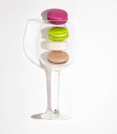 some sweet colored macaroons in glass shaddow white isolated frenchの写真素材