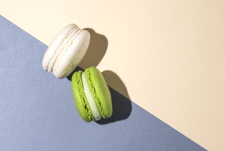 two sweet  macaroons green vanilla gray beige background shadow art top view free spaceの写真素材