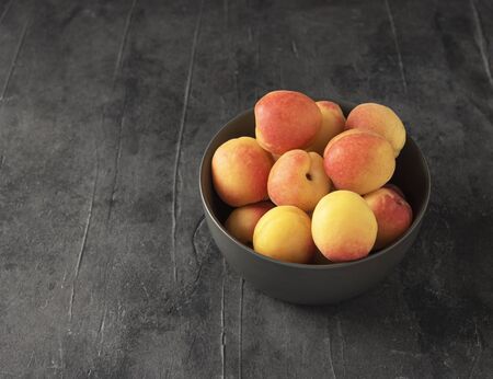 sweet delicious apricot on dark bowl grey table summer fresh fruitの写真素材