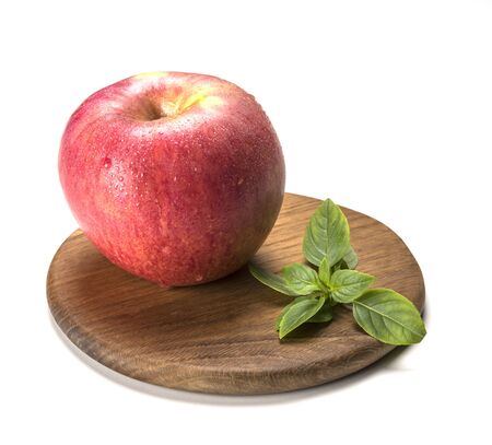 fresh sweet red apple wet on brown wood board with mint isolatedの写真素材