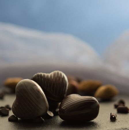 some sweet chocolate hearts with nuts blue background close up morning light macroの写真素材