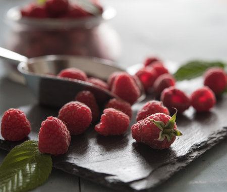 some fresh sweet scatter raspberry on shale summer morning light close up