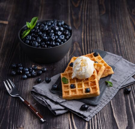 fresh sweet blueberry with aromatic belgian waffels vanilla ice cream and honey dark wood table rusticの写真素材