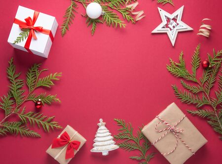 New Year Christmas flat lay craft box presents, toys and green tree on red background. Image  top view and copy space.Xmas holiday  celebrationの写真素材