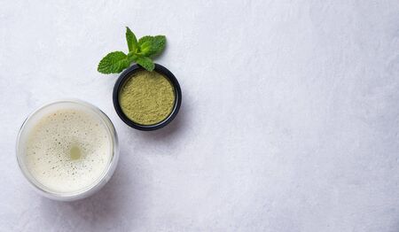 Japanese green matcha tea latte in clear glass on white background. Diet and vegan drink. Top view and copy spaceの写真素材