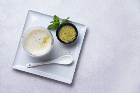 Japanese green matcha tea latte in clear glass on white background. Diet and vegan drink. Top view and copy spaceの写真素材