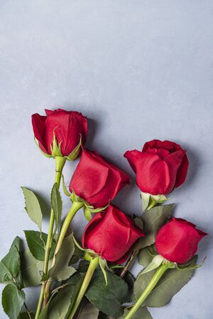 A beautiful and delicate bouquet of red roses lies on a blue background . Valentines day. Top view and copy space
の写真素材