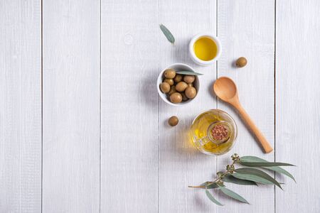ripe natural eco friendly olives with olive oil in a bottle on a white wooden background. Vegan and dietary product. Top view, flat  lay and copy spaceの写真素材