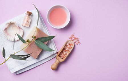 natural organic cosmetics with pink Himalayan salt, soap and eucalyptus branch on a pink background. Aromatherapy and Spa treatments. Top view, flat lay and copy spaceの写真素材