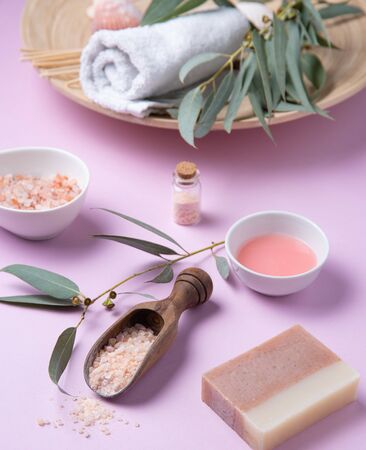 natural organic cosmetics with pink Himalayan salt, soap and eucalyptus branch on a pink background. Aromatherapy and Spa treatmentsの写真素材
