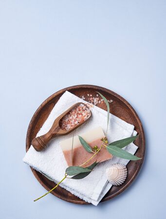 natural organic cosmetics with pink Himalayan salt, soap and eucalyptus branch on a blue  background. Aromatherapy and Spa treatments. Top view, flat lay and copy spaceの写真素材