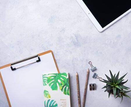 Home work. Business flat lay with note, pencil, tablet  and cucculent, on white beton background.Image top view, flat lay and copy spaceの写真素材