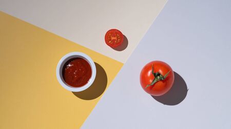 Fresh juicy tomato and ketchup on multicoloredの写真素材