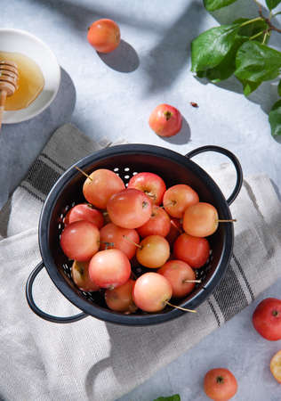 Small juicy apples lie in a bowl on a linen towel. Rustic style, top viewの写真素材
