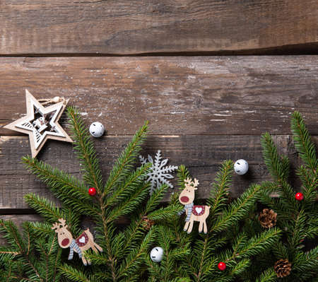 Wooden old vintage background with Christmas tree branches and craft  toys. Holiday greeting card. Copy space, top view and flat lay.の写真素材